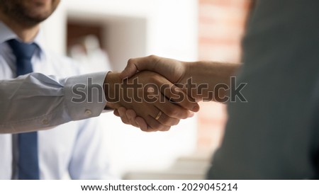 Close up view two businessmen shaking hands after successful formal negotiations. Male HR manager handshake hire candidate at job interview. Mutual respect, business etiquette, make agreement concept Royalty-Free Stock Photo #2029045214