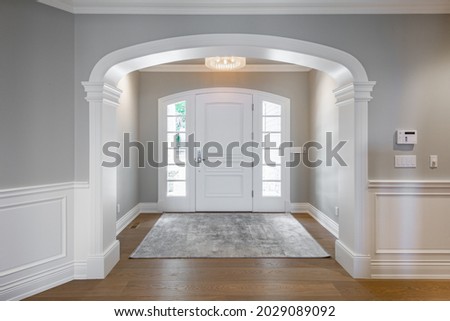 Grand foyer with white doors and elegant staircase and wraught iron Royalty-Free Stock Photo #2029089092