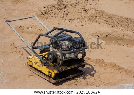 Manual ramming machine for compacting soil. Pebble construction machine on the construction site. Sand-laying machine Royalty-Free Stock Photo #2029103624