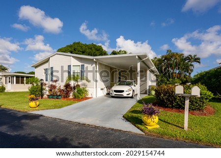 Photo of a mobile home in a trailer park with car in driveway Royalty-Free Stock Photo #2029154744