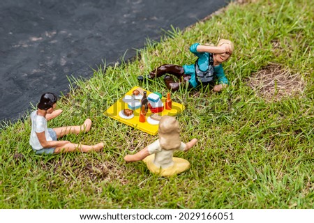 Closeup of tiny model people having a picnic