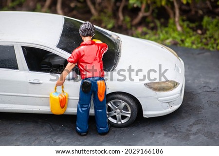Closeup a of tiny model man washing his car