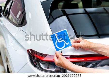Scene of putting a wheelchair mark on a car Royalty-Free Stock Photo #2029170275