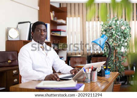Doctor working in medical office using laptop computer