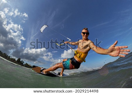 Kite surfer jumps with kiteboard in transition 