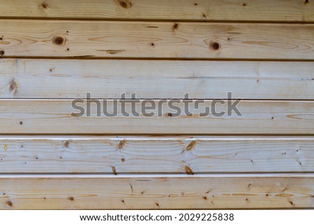 a light brown wooden wall made of several wooden boards. a light natural texture pattern. a background for image editing. 