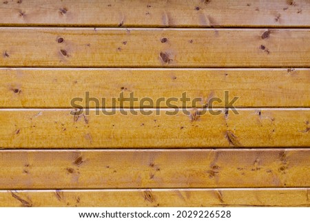 a light brown wooden wall made of several wooden boards. a light natural texture pattern. a background for image editing. 