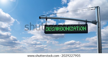 Road information board with text DECARBONIZATION on a background of blue sky. Carbon neutrality concept Royalty-Free Stock Photo #2029227905