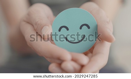 Hands holding green happy smile face, good feedback rating and positive customer review,experience, satisfaction survey,mental health assessment,child feeling good,world mental health day, Compliment  Royalty-Free Stock Photo #2029247285
