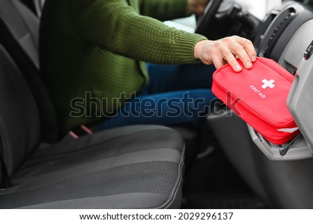 Man taking first aid kit from car's glove compartment Royalty-Free Stock Photo #2029296137
