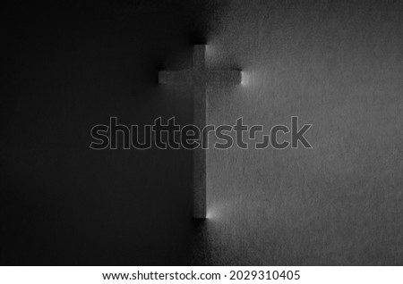 The cross pressing through black fabric with shine and dark side for Halloween background concept.