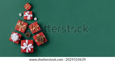 Gift boxes with white and brown bows in the shape of a Christmas tree on a green background. Christmas background. Top view.