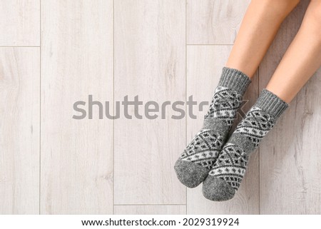 Legs of young woman in socks on wooden background