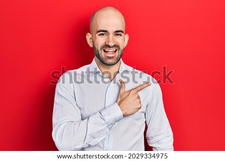 Young bald man wearing elegant clothes smiling cheerful pointing with hand and finger up to the side 