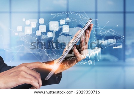 Businesswoman wearing formal suit is touching a tablet with digital interface with globe, cloud data, padlock, coin icons. Blurred office in background. Concept of international business and network