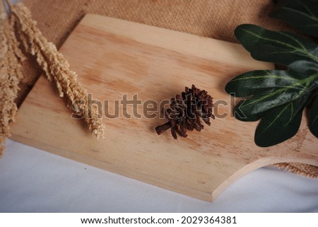 pine cones, leaves, wooden cutting board and wheat on a white cloth background and burlap sacks. soft and vintage photo concept for design or decoration material