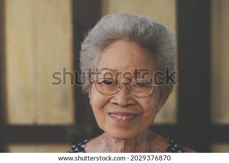 Portrait of Asian Senior retirement woman smile wrinkles with casual clothing standing in home happy lifestyle. Elderly Grandma. Southeast Asia Ethnicity Good Healthy. retro style copy space.