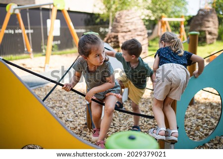 Group of small nursery school children playing outdoors on playground. Royalty-Free Stock Photo #2029379021