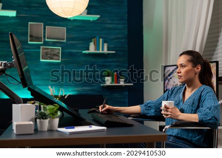 Photo editing software expert retouching work at desk while using professional digital tablet stylus interface on computer monitor. Woman with editor occupation working on image photo
