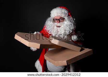 Cute and fat Santa Claus delivers pizza in boxes. Black background.