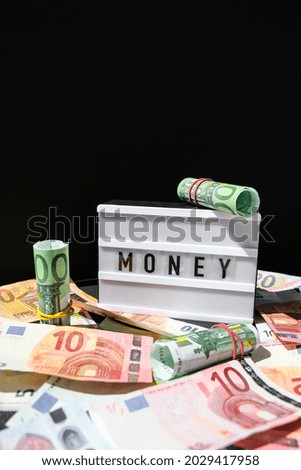 Lightbox board with the word MONEY in black letters around Euro banknotes. Finance background. Business, financial success and making money concept. Business budget of wealth and prosperity finance. 
