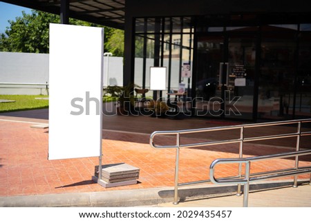 Blank white outdoor advertising standsandwich board mock up template. Clear street signage board placed by an outdoor dinning area of a restaurant. Background texture of standee on street.