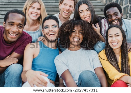 Young group of people smiling on camera having fun outdoor in the city - Focus on african girl face