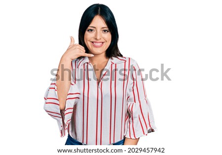 Young hispanic girl wearing casual clothes smiling doing phone gesture with hand and fingers like talking on the telephone. communicating concepts. 