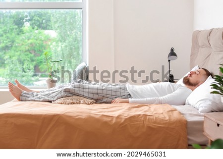 Young man sleeping in bed at home Royalty-Free Stock Photo #2029465031