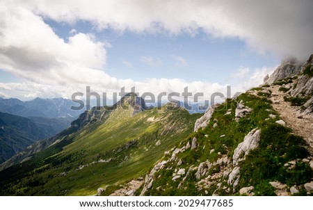 The high Plateau of Montasio with green pastures in summer and Julian Alps (Jof di Montasio). Udine, Friuli Venezia Giulia, Italy, Europe