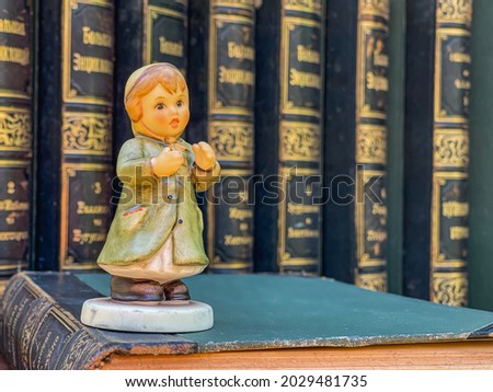 Pretty girl  figurine on old book background.