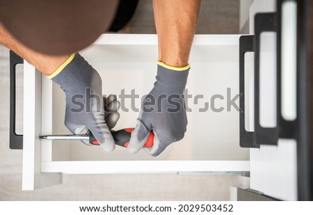 Professional Cabinetmaker Finishing Kitchen Cabinet Drawers Installation. Top View Close Up. Home Improvement Theme. Royalty-Free Stock Photo #2029503452