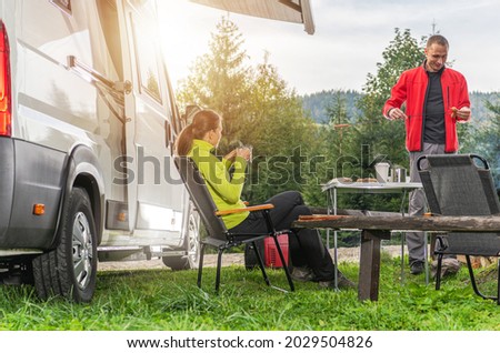 Caucasian Couple in Their 30s and Camper Van Road Trip. Recreational Vehicle and a Campsite Place. Rving Theme. Royalty-Free Stock Photo #2029504826