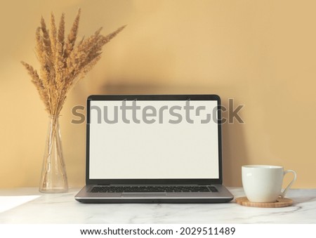 Mock up screen laptop on beige nature background. Minimal business computer frame and blank display concept for presentation.