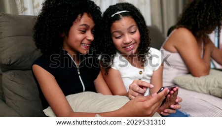 Two little girls looking at smartphone screen