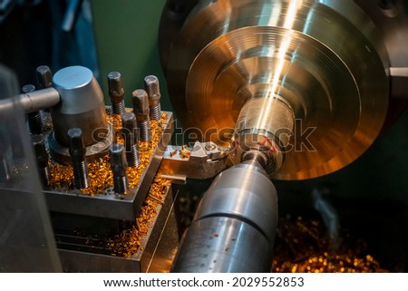 The lathe machine operation by peel-off cutting at brass material parts by lathe tools. The metalworking process by turning machine.