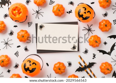 Top view photo of black envelope spiders on white card pumpkin baskets candy corn straws web and bats silhouettes on isolated white background with blank space