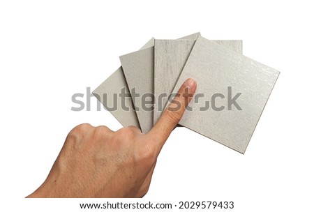 designer's hand selecting (pointing) concrete ceramic tile samples swatch, multi texture, isolated on white background with clipping path. top view of tile in square shape samples for selection.
