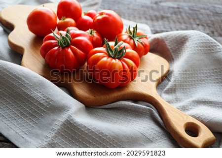Fresh tomatoes on vintage wooden table ready for cooking .