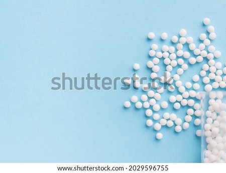 Homeopathy medicine alternative herbs. Homeopathic globules and glass bottle on a blue background. Health care and medicine concept. Royalty-Free Stock Photo #2029596755