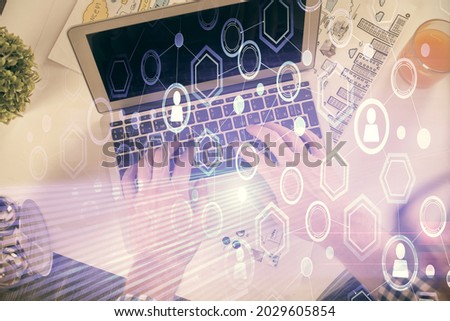 Double exposure of man's hands typing over computer keyboard and social network theme hologram drawing. Top view. People connection web concept.
