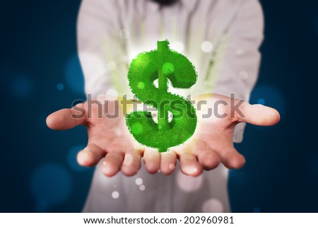 Young business man in suit presenting green glowing dollar sign