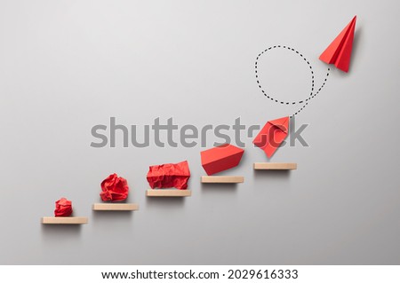 Wooden steps with different stages of making a paper airplane, creating something from nothing success concept Royalty-Free Stock Photo #2029616333
