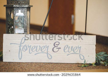 A selective focus shot of a wooden sign that says "Forever   Always "
