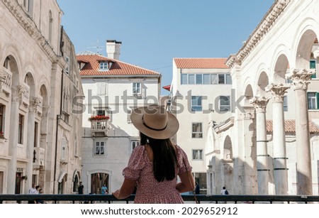 Rear view of woman standing on Peristyle or Peristil of ancient roman palace built by emperor Diocletian in Split, Croatia  Royalty-Free Stock Photo #2029652912