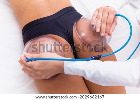 Woman using suction cup pump up on her butt to lift it up. Royalty-Free Stock Photo #2029662167