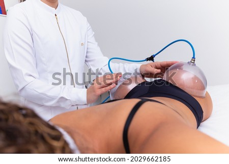 Woman using suction cup pump up on her butt to lift it up. Royalty-Free Stock Photo #2029662185