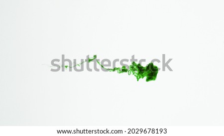 Isolated Green Ink Cloud floating in clear water. Macro Slow Motion Shot on White Background with selective focus framed for vertical video