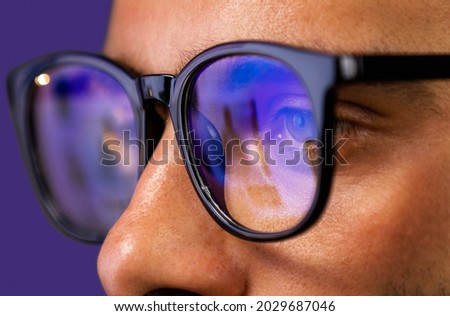 Close up view of focused businessman reading, watching, working online, wears computer glasses for reducing eye strain blurred vision Royalty-Free Stock Photo #2029687046