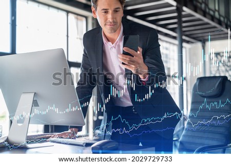 Businessman in suit using smart phone to optimize trading strategy at corporate finance fund. Forex chart hologram over modern panoramic office background